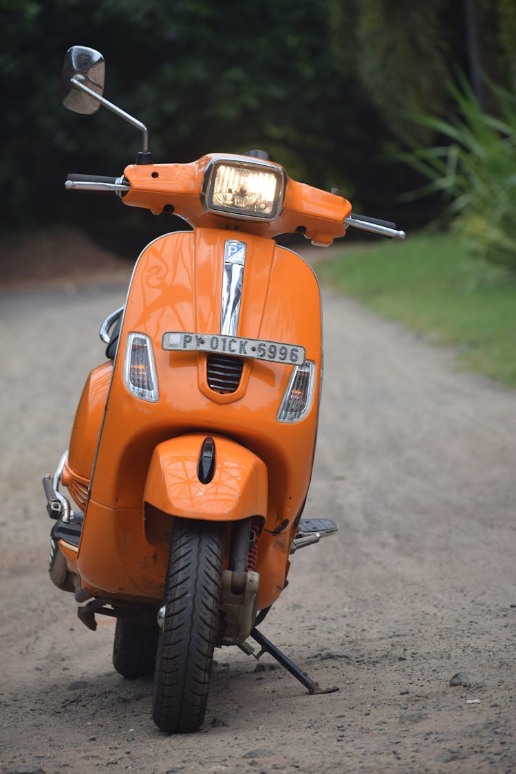 An Orange Scooter Parked On The Road