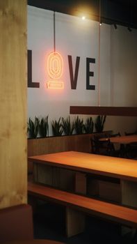 Warm café setting in Istanbul featuring a neon sign spelling 'Love' on the wall.