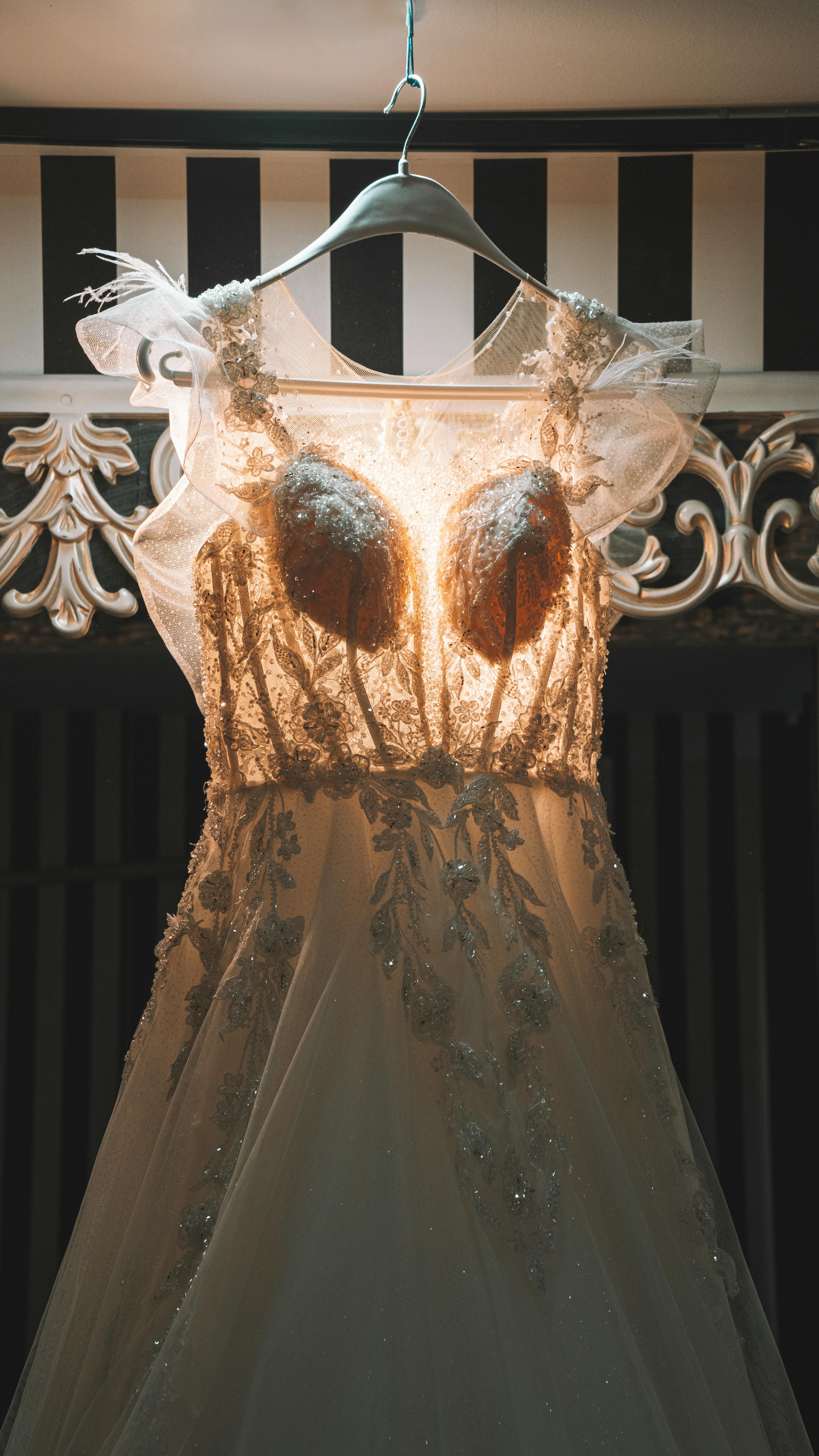 Stunning bridal gown elegantly displayed with intricate details and warm lighting for an unforgettable wedding.