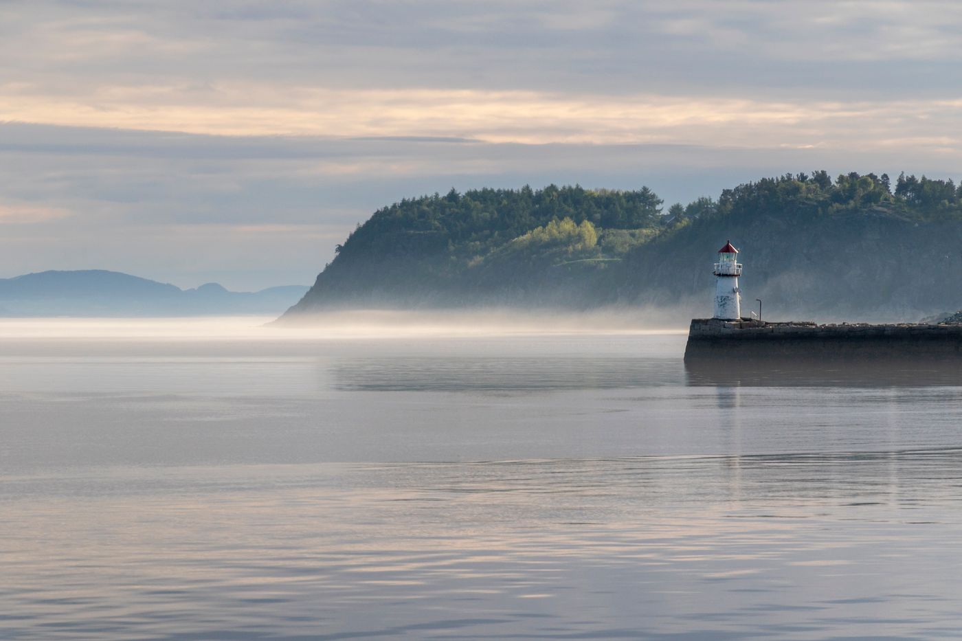 Misty headland with a small lighthouse
