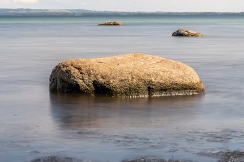 Brown Rock Formation on Body of Water