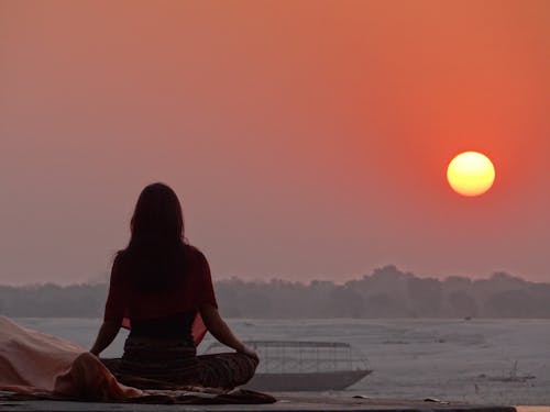 Free Woman Doing Yoga Near Sea during Sunset Stock Photo