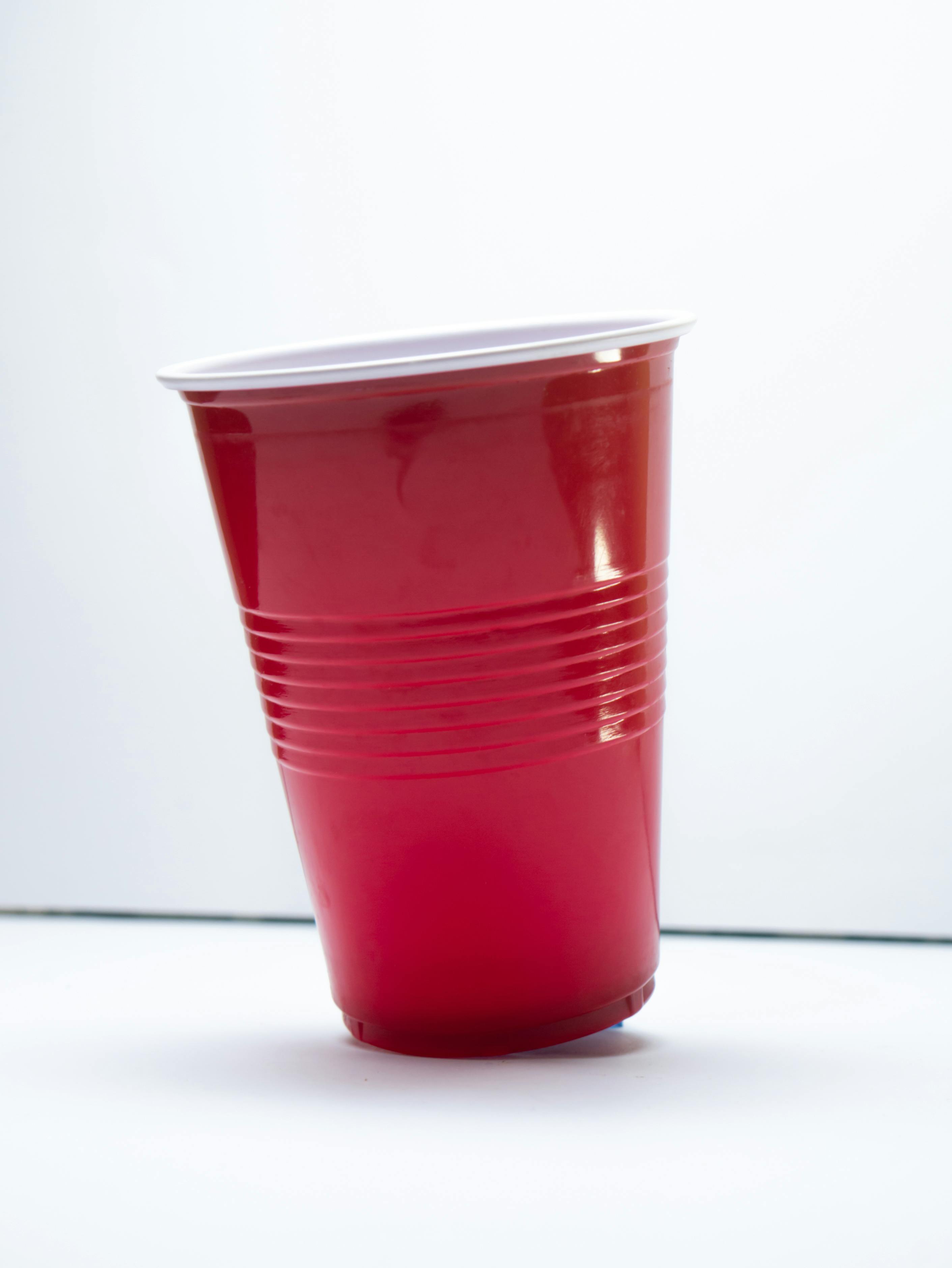 Red Cups Beside Small Balls on a White Surface · Free Stock Photo