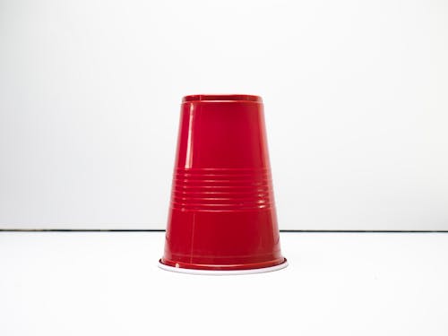 Close-Up Shot of a Red Plastic Cup on White Surface