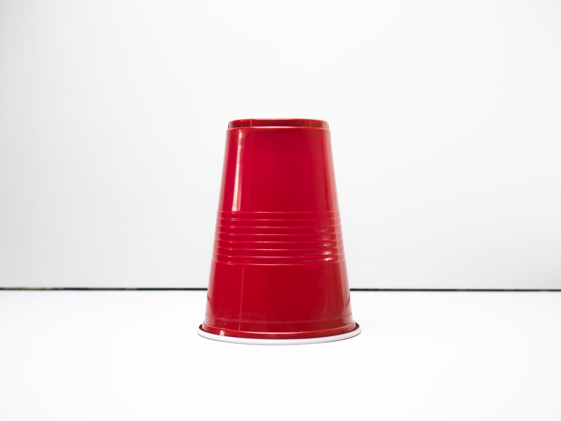 Close-Up Shot of a Red Plastic Cup on White Surface