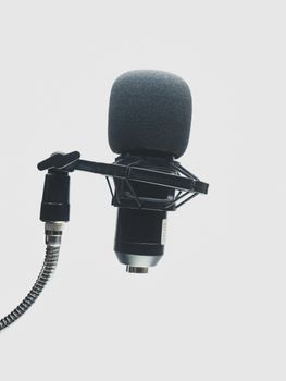 High-quality condenser microphone with stand in a music studio setting.