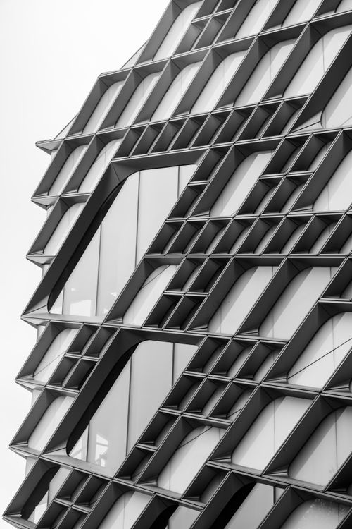 Free Monochrome view of a geometric modern building facade with intricate patterns. Stock Photo