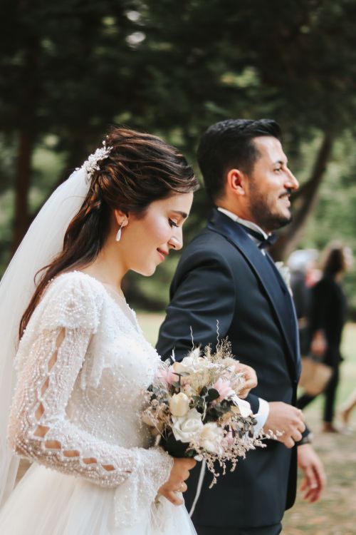Free Bride and groom walking joyfully during an outdoor wedding ceremony. Stock Photo