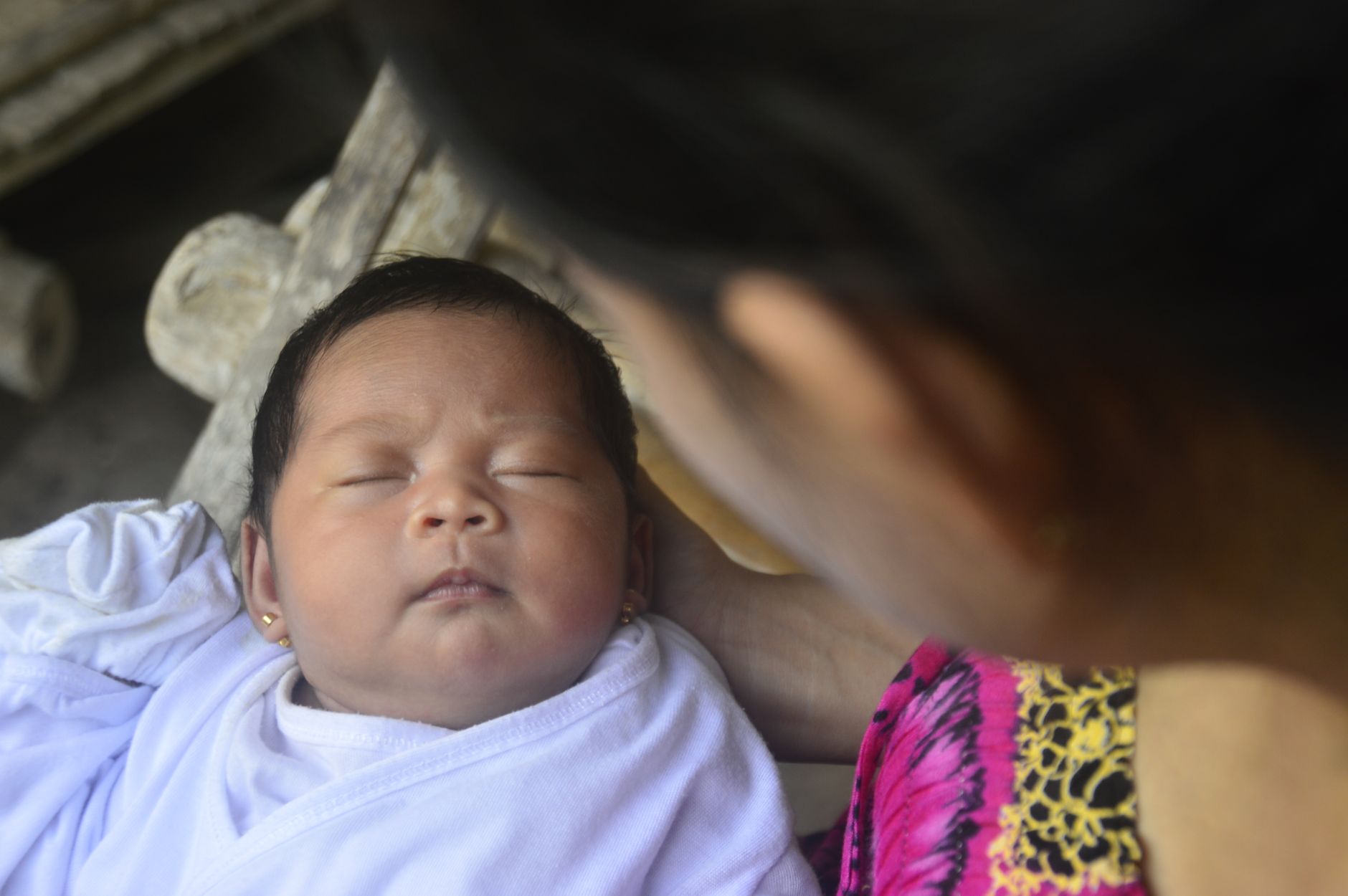 A tender moment of a mother gazing at her sleeping baby, capturing warmth and love.