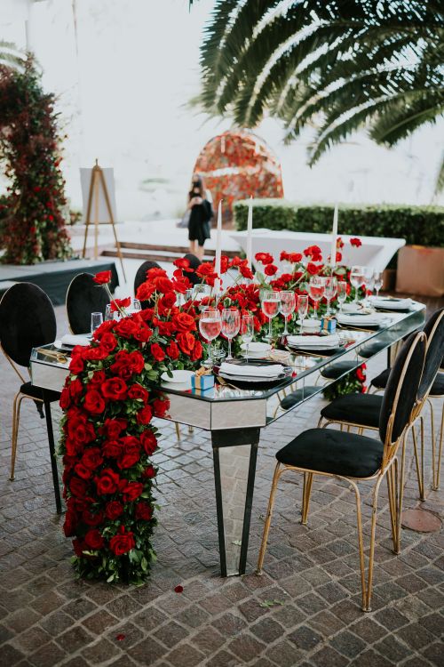 Free Outdoor dining setup with red roses and elegant tableware, perfect for romantic events. Stock Photo