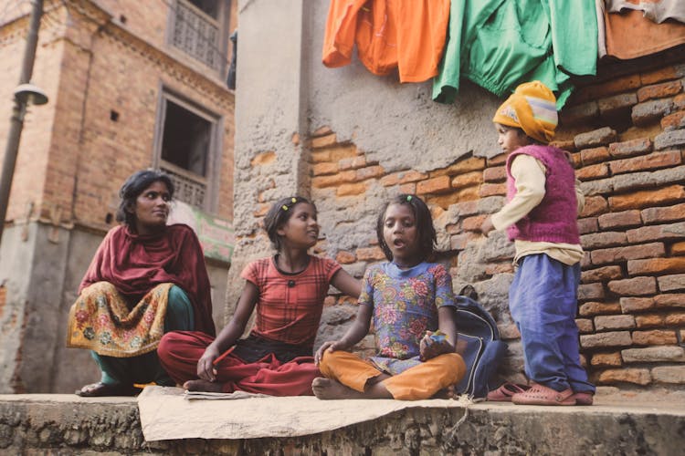 Woman Watching Little Girls Study Outdoors