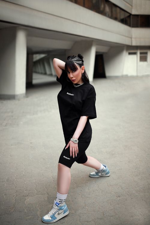 Free Stylish woman in black streetwear posing confidently in an urban setting. Stock Photo