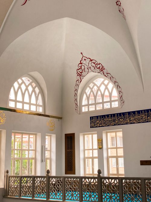 Free Captivating view inside an Istanbul mosque featuring beautiful Arabic calligraphy and arched windows. Stock Photo