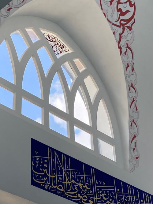 Free Stunning arch windows and Arabic calligraphy in an İstanbul mosque, reflecting Islamic architecture. Stock Photo
