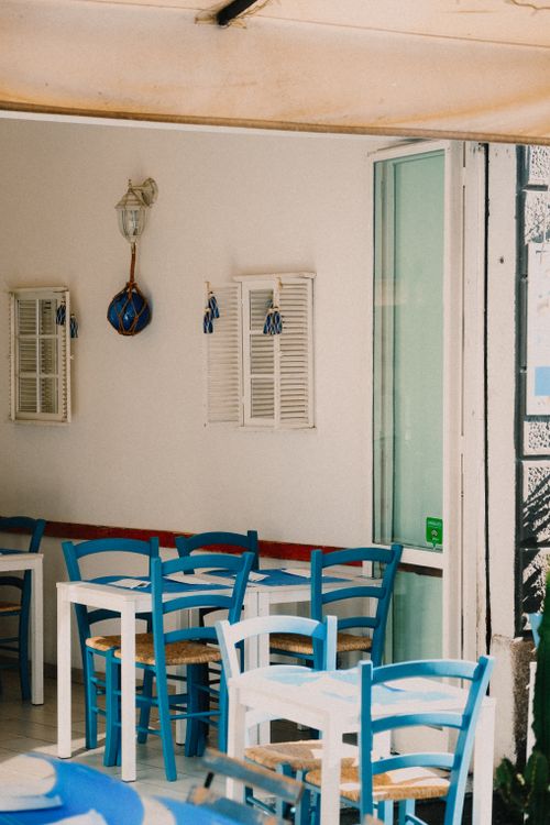 Free Inviting indoor restaurant setting featuring blue chairs and a Mediterranean vibe. Stock Photo