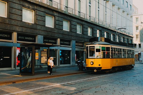 People Waiting for the Tramway Moving on the Road