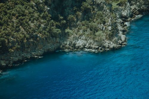 Free Stunning aerial shot of Muğla's rocky coastline and vibrant blue waters in Türkiye. Stock Photo
