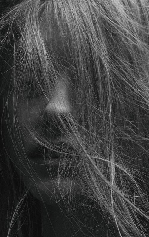 Free Artistic close-up monochrome portrait of a woman with messy hair in a vertical shot. Stock Photo