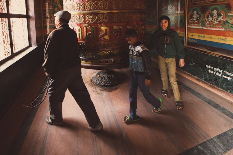 Man And His Sons Walking Around Prayer Wheel