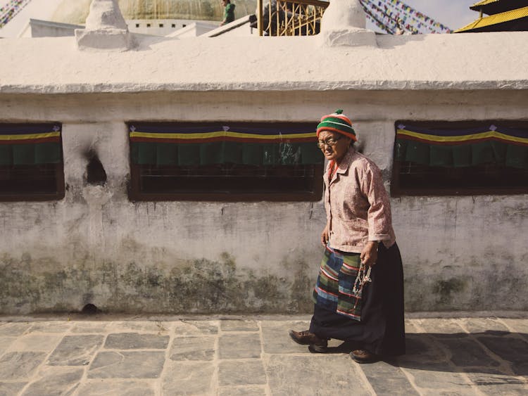 Elderly Woman Wearing Beanie Walking On The Sidewalk