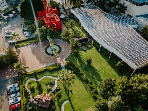 Free Stunning aerial shot showcasing a vibrant garden and striking red building from above. Stock Photo
