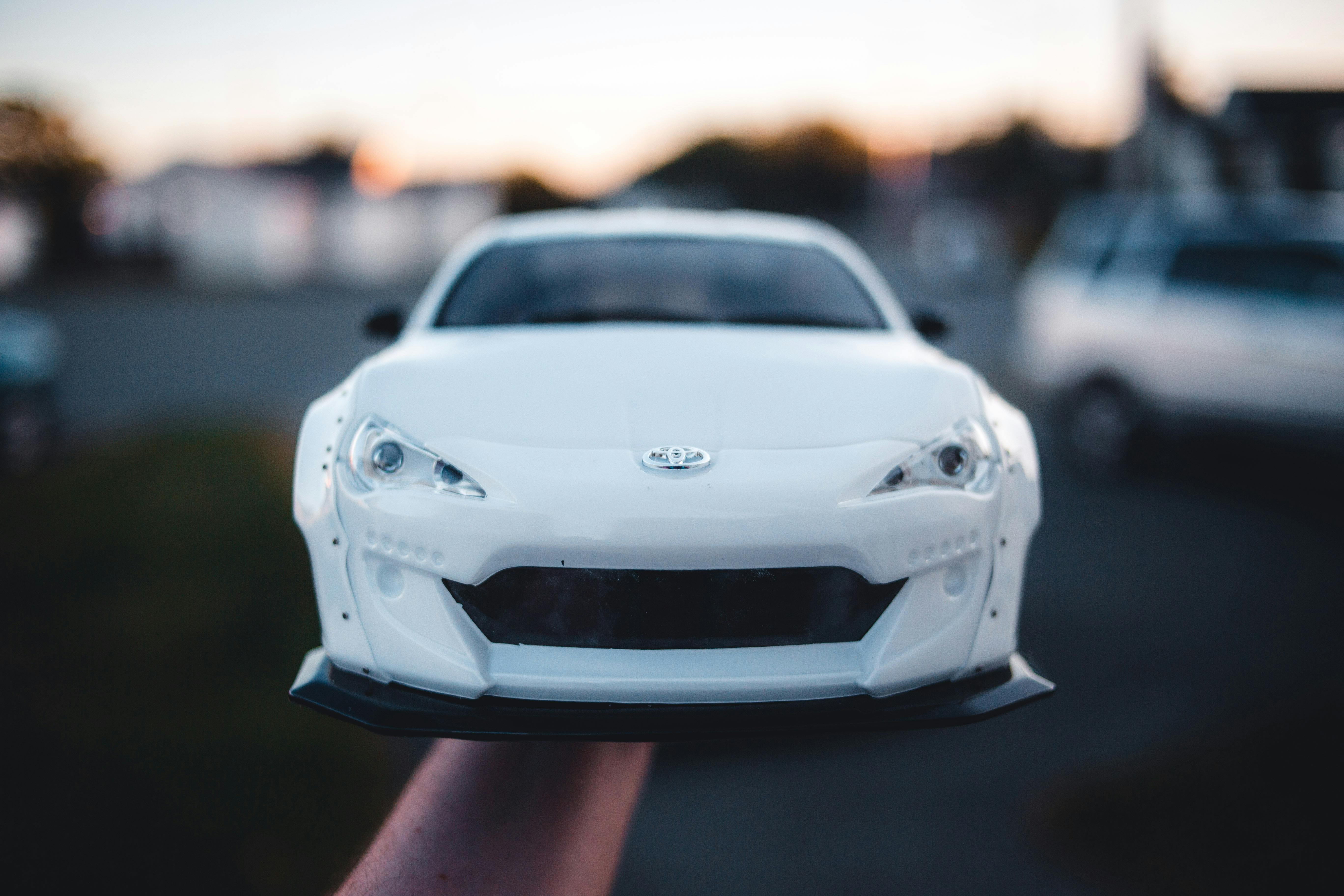 person holding a white toy car