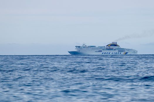 A luxury cruise ship sails calmly on the sea near Corfu, Greece, offering a serene travel experience.