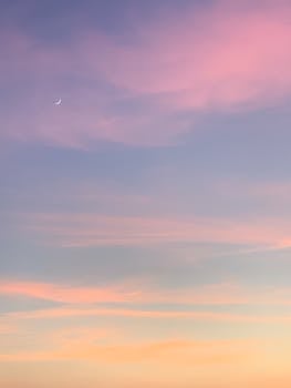 A tranquil twilight sky with pastel hues and a crescent moon, perfect for relaxing backgrounds.