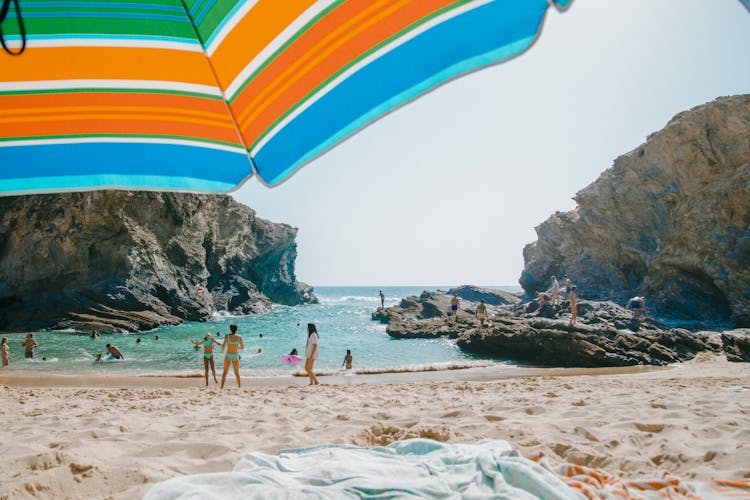 A People Swimming On The Beach Together 