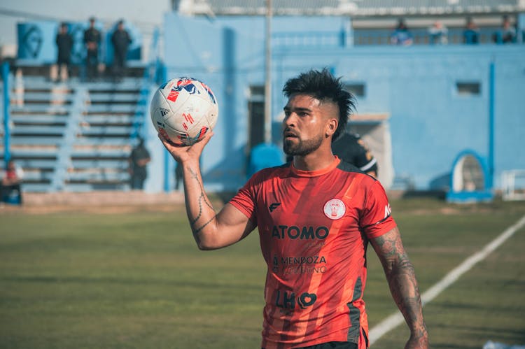 A Man Holding A Soccer Ball