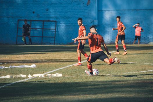 Dynamic soccer action captured in Mendoza, Argentina. Players in red jerseys showcase teamwork on the field.