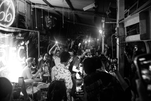 Exciting live band performance in a crowded underground venue captured in black and white.
