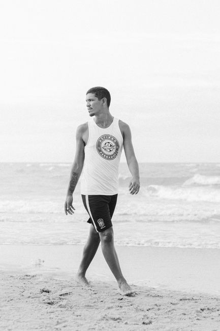 A man walks along the beach at Canoa Quebrada, captured in monochrome.