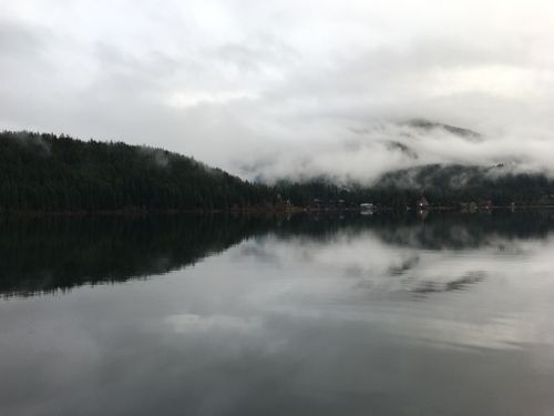 Free Serene misty lake reflection with fog and forested mountains in Whistler, BC, Canada. Stock Photo