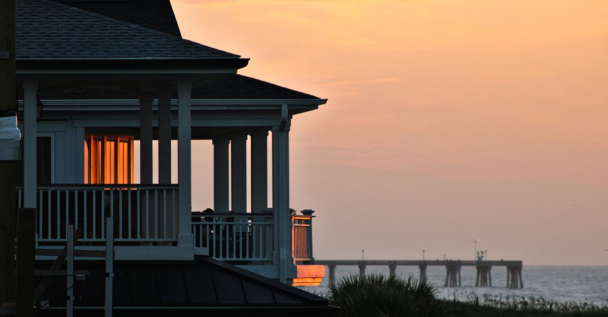 Beautiful beachfront house with ocean view at sunset creating a serene atmosphere.