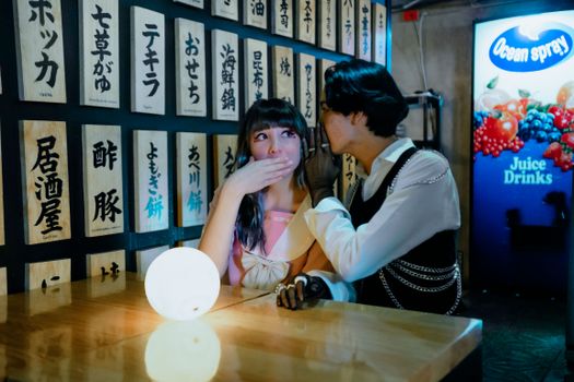 A young couple whispers privately at a Japanese-themed restaurant in Mexico City.