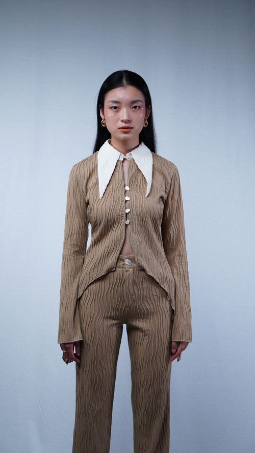 Free Portrait of an Asian woman in a stylish brown outfit in a photoshoot setting, showcasing modern fashion. Stock Photo