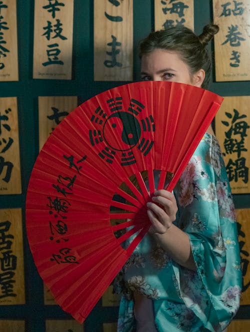 A Woman Holding a Red Hand Fan