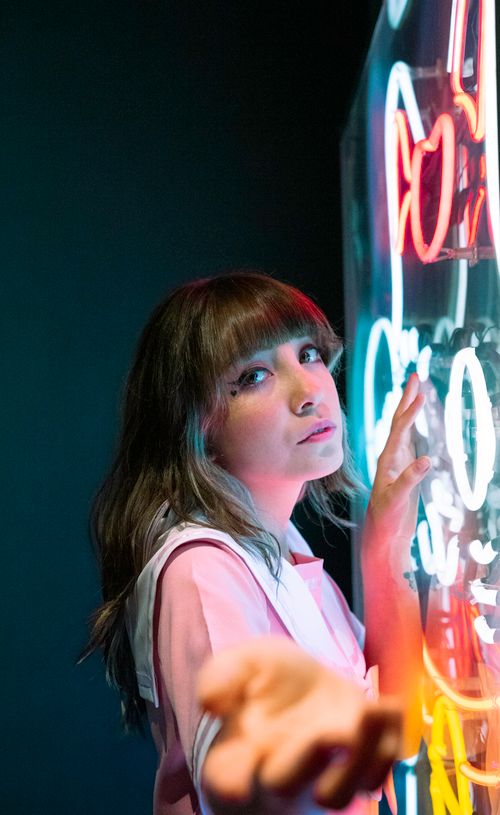 Free A young woman in Mexico City poses creatively against a bright neon backdrop, offering a dynamic and colorful scene. Stock Photo
