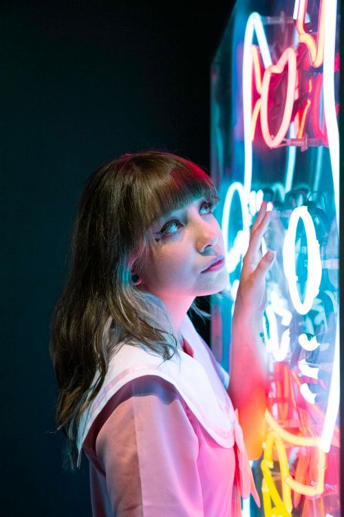 Free Woman in Ciudad de México gazing at vibrant neon art, creating a reflective mood. Stock Photo