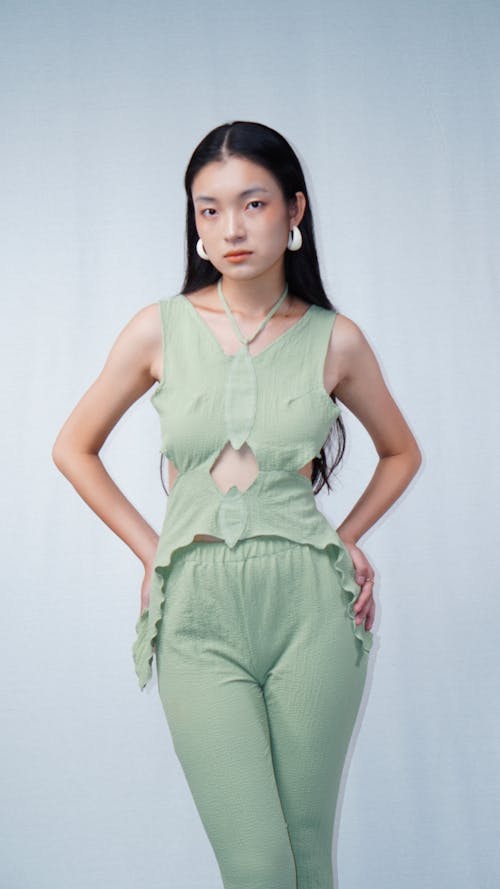 A Woman Wearing Green Sleeveless Blouse and Green Pants