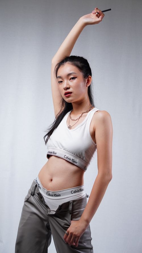 Free Confident woman in chic outfit striking a pose in studio setting. Stock Photo