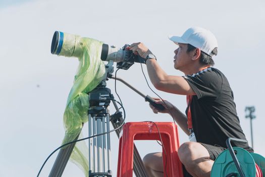 A Man in White Cap Looking through the Binoculars