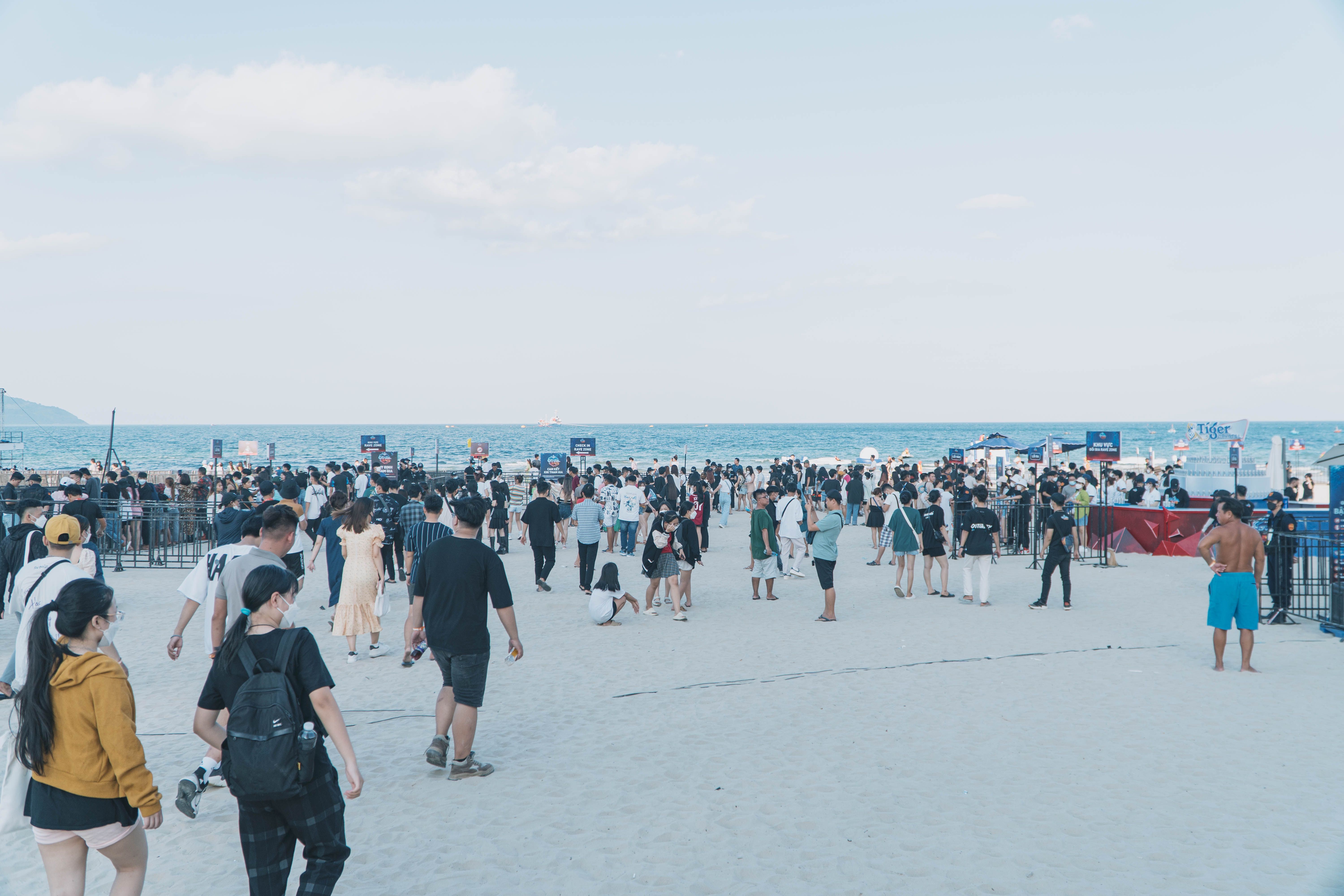 A large group of people enjoying a day at the beach with clear blue skies. — Trójmiasto