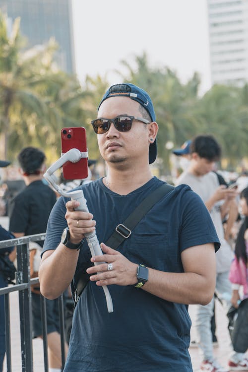 A Man Holding a Phone on Selfie Stick 
