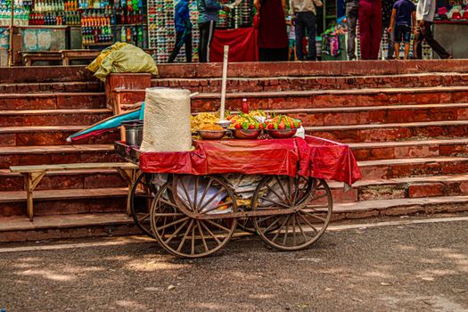 Vibrant street food scene with a wooden cart offering fresh snacks in a bustling market setting.