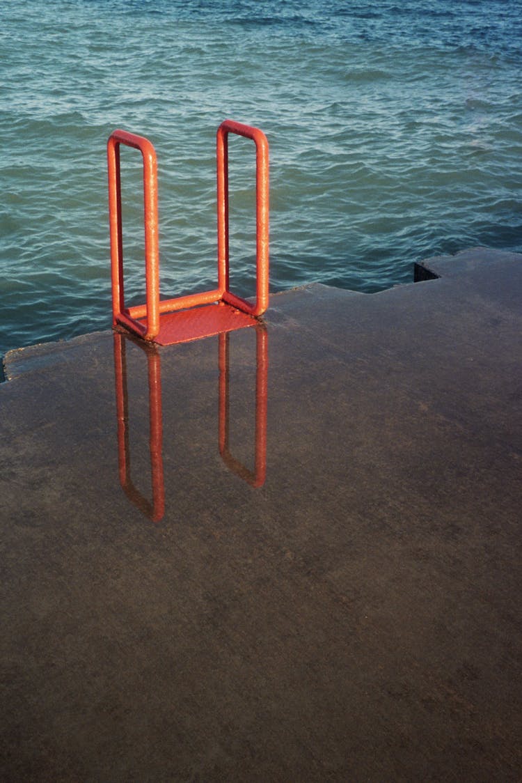 Red Metal Ladder Near The Sea