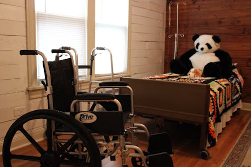 White and Black Wheelchair beside Brown Bed