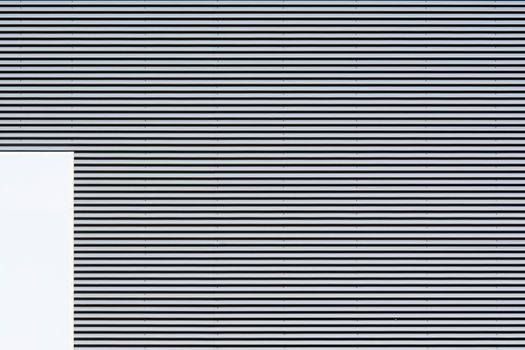 Abstract minimalist composition of a striped wall with geometric patterns and textures.
