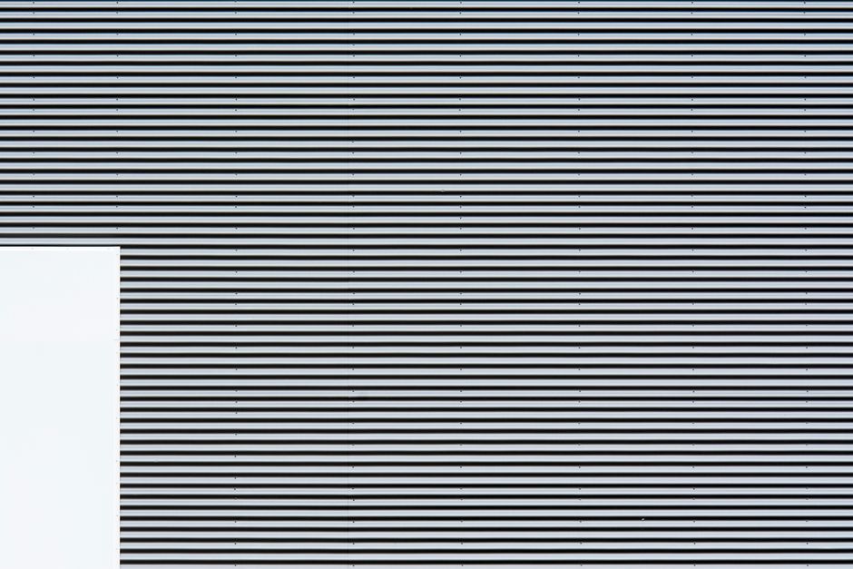 Abstract minimalist composition of a striped wall with geometric patterns and textures.